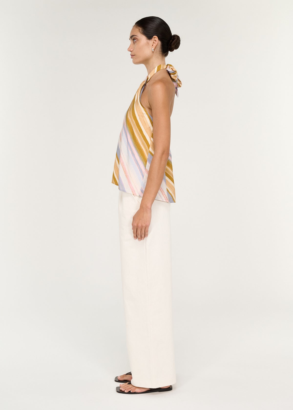 Side view of the Pastel Stripe Twist Detail Halter Top, showing a relaxed fit and a hip length.