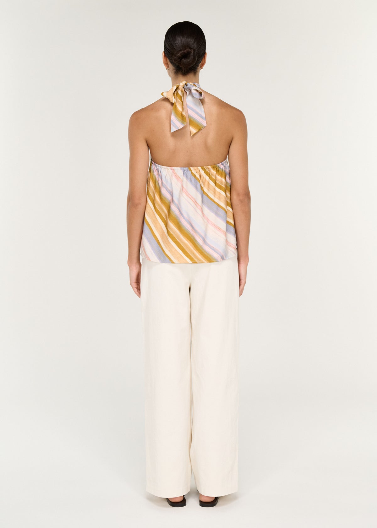 Back view of the Pastel Stripe Twist Detail Halter Top with an adjustable tie at back neck and an open back.