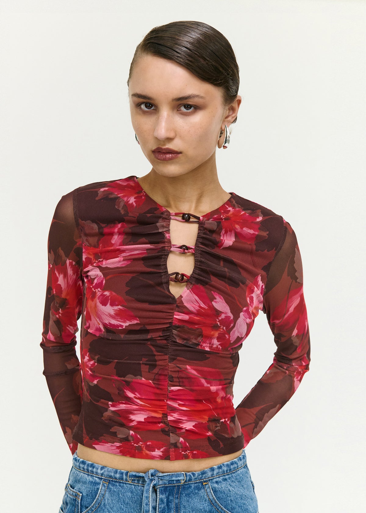 Close-up of the Pink Floral Print Mesh Bead Detail Top, showing a front cut-out neckline detail and long sheer sleeves.