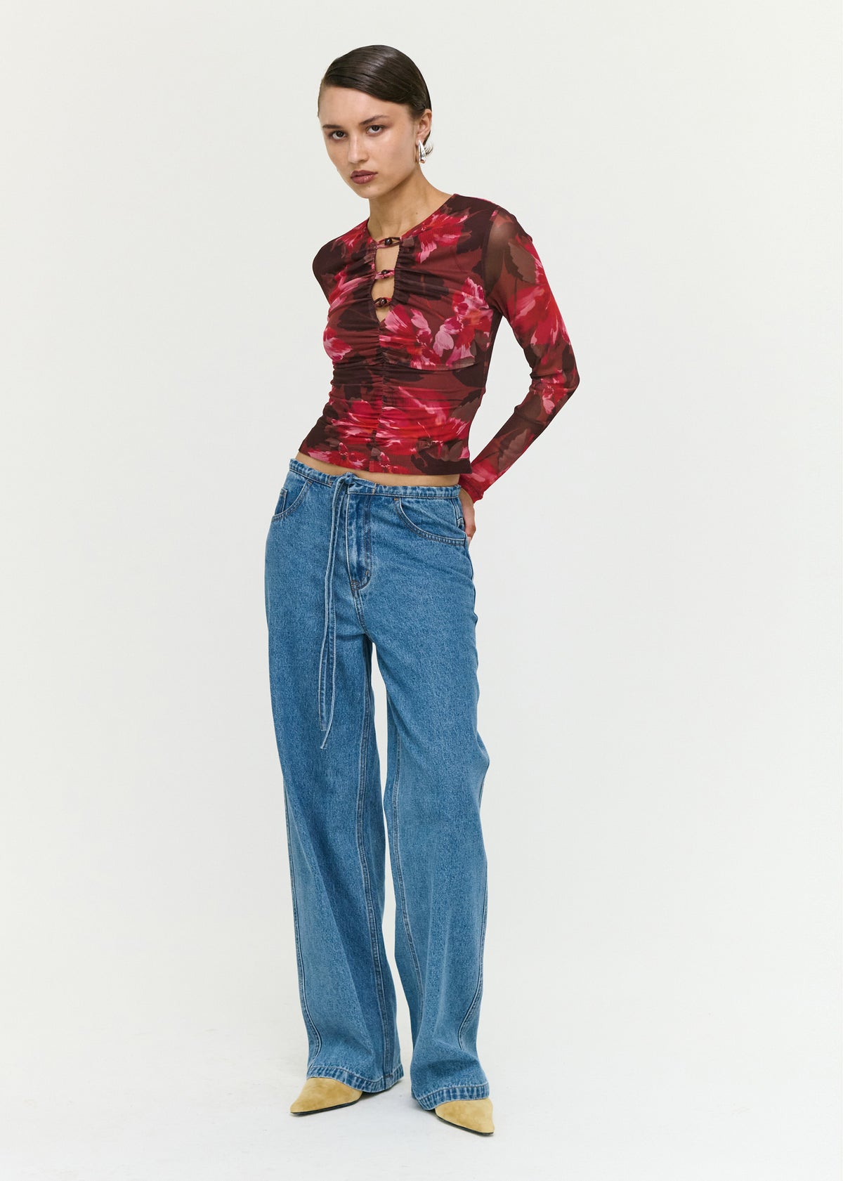 Angled view of the Pink Floral Print Mesh Bead Detail Top with long sheer sleeves and a cropped length.