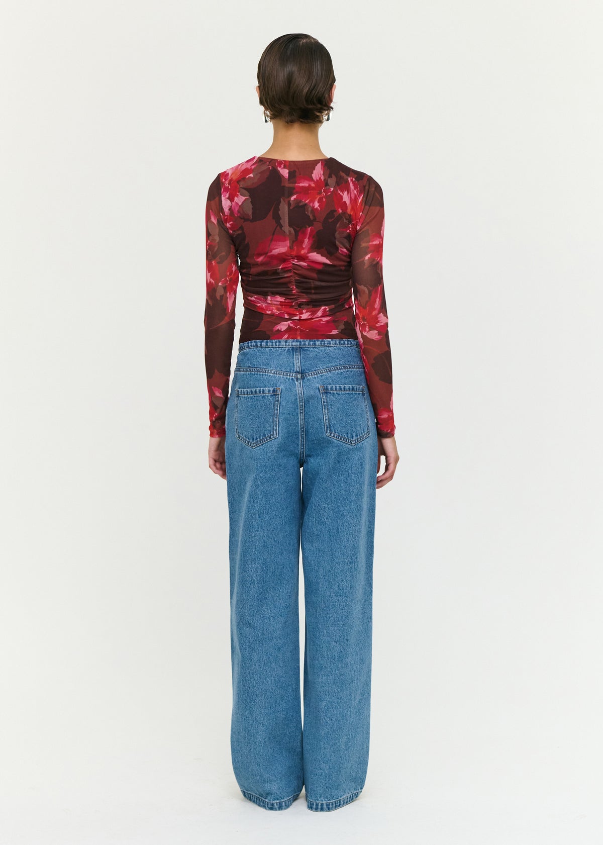 Back view of the Pink Floral Print Mesh Bead Detail Top with a sheer mesh fabrication and an oversized floral print.