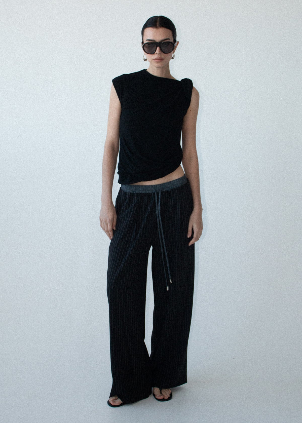 Model wearing Pinstripe Relaxed Drawstring Pants, showing a relaxed wide-leg silhouette and an elasticated waistband.