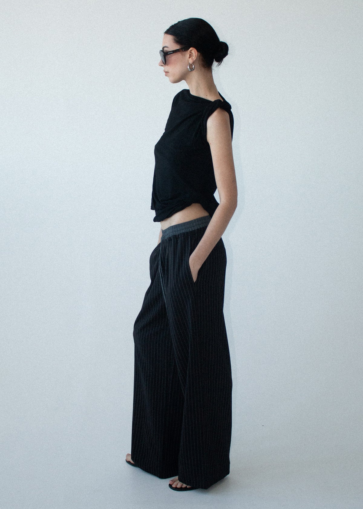 Angled view of the Pinstripe Relaxed Drawstring Pants with a full length fit and a soft woven fabrication.