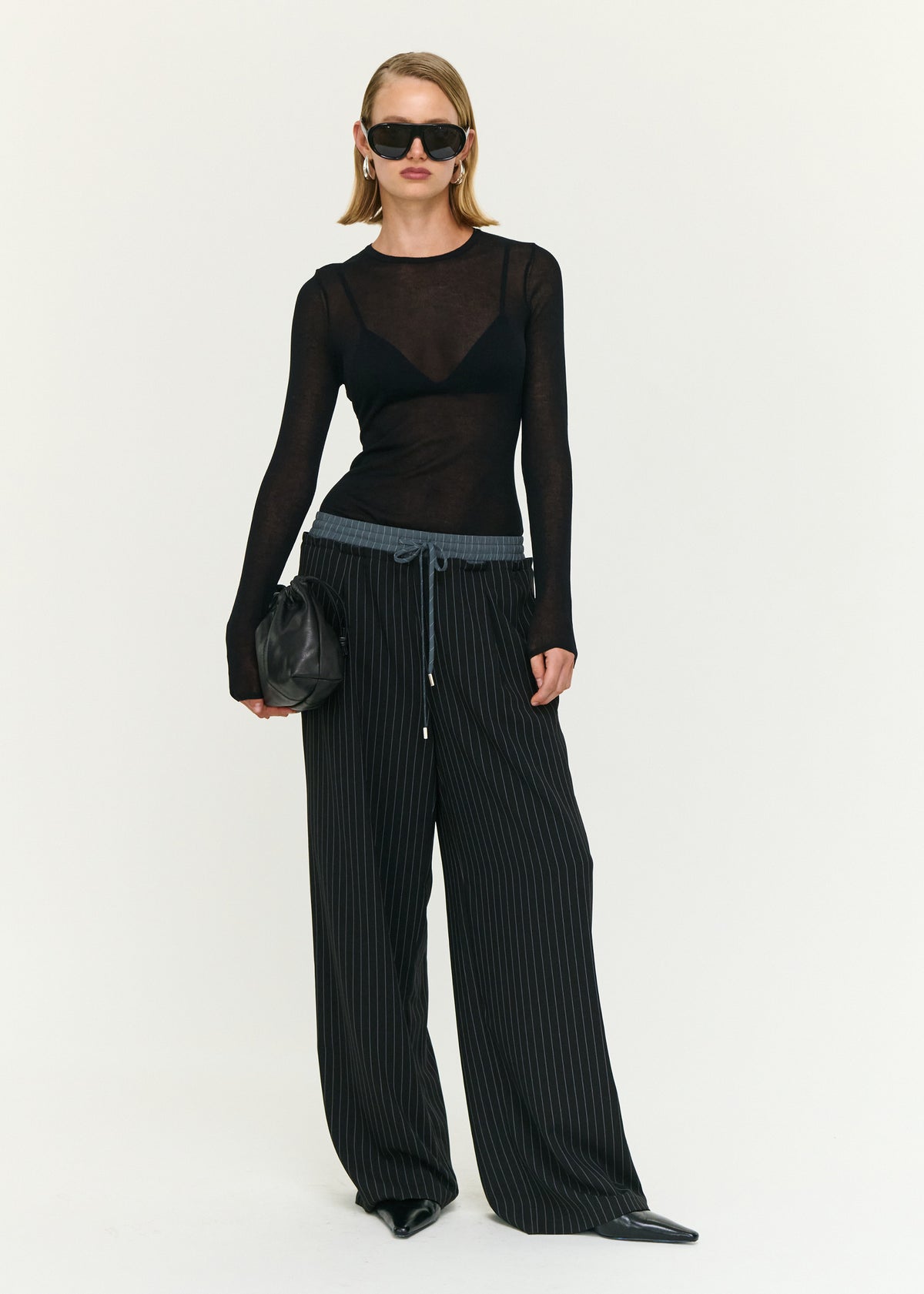 Model wearing Pinstripe Relaxed Drawstring Pants with an elasticated waistband and an adjustable drawcord tie.