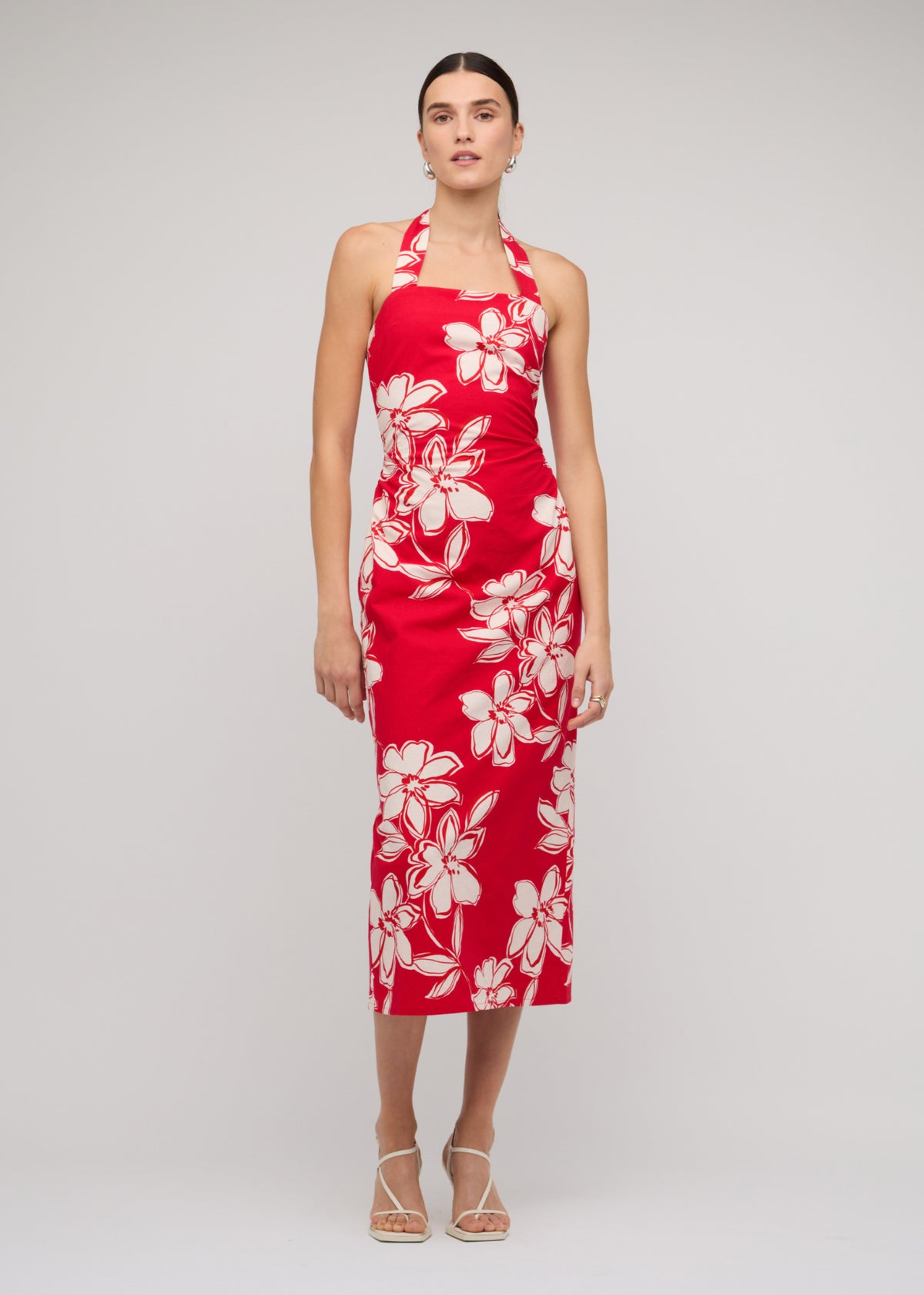 Model wearing Red and White Cotton Floral Halter-Neck Midi Dress with a red with white floral print (front angled).