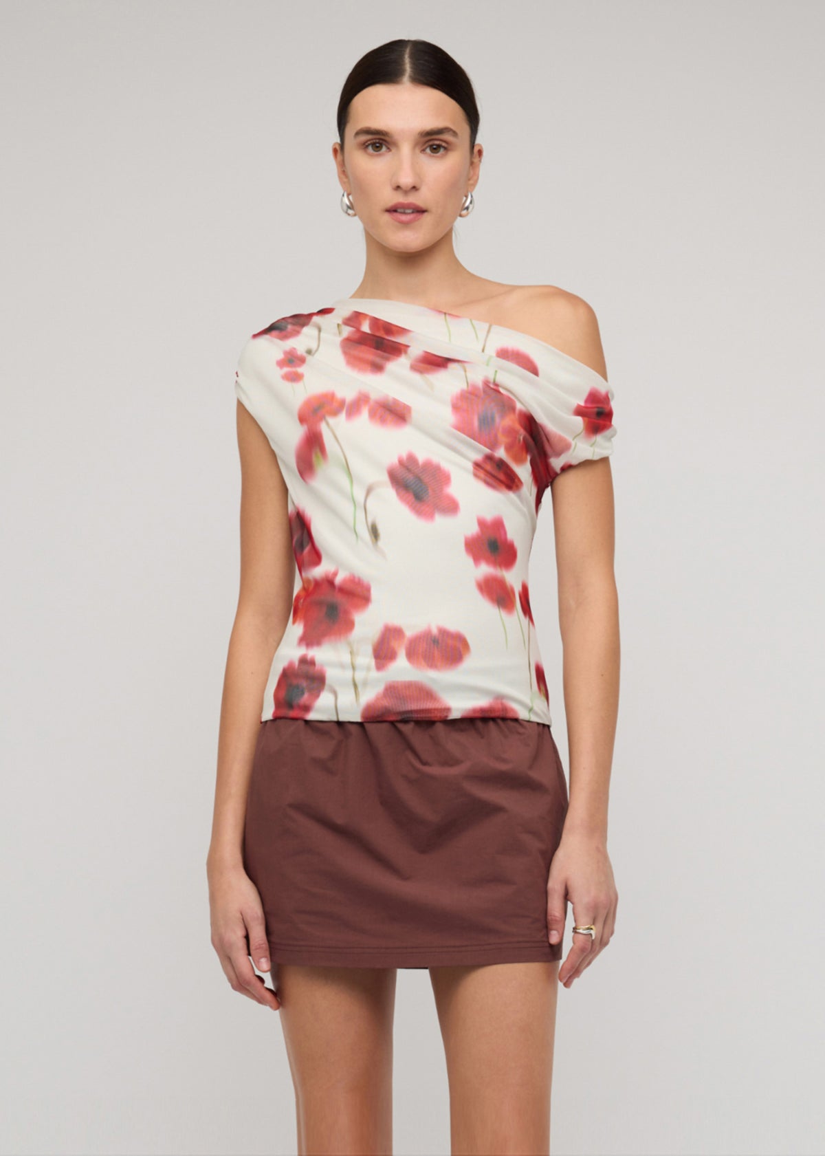 Close-up of the Red and White Poppy Print Off-Shoulder Mesh Top, showing a one-shoulder draped neckline and a blurred floral print.