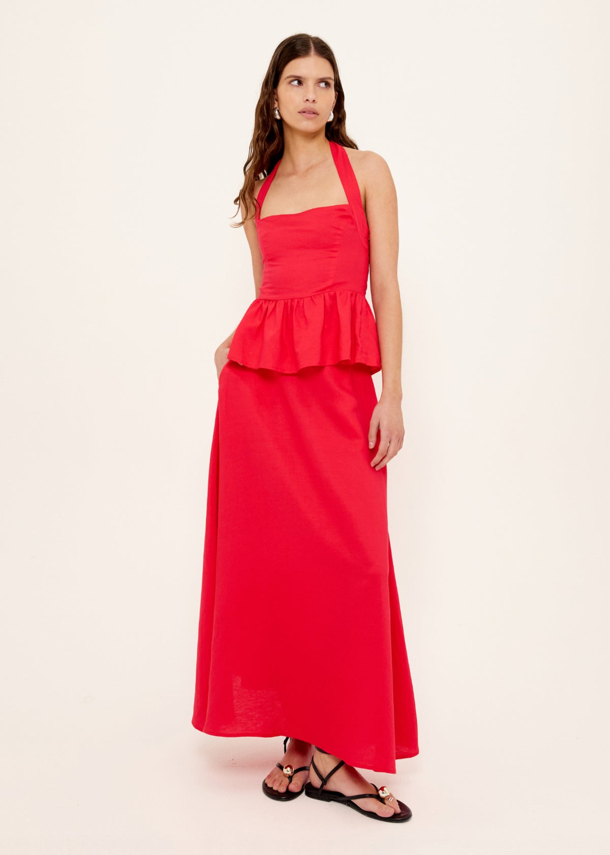 Model wearing Red Linen Blend Halter Peplum Top with a halter neckline with tie back and a shirred back panel.