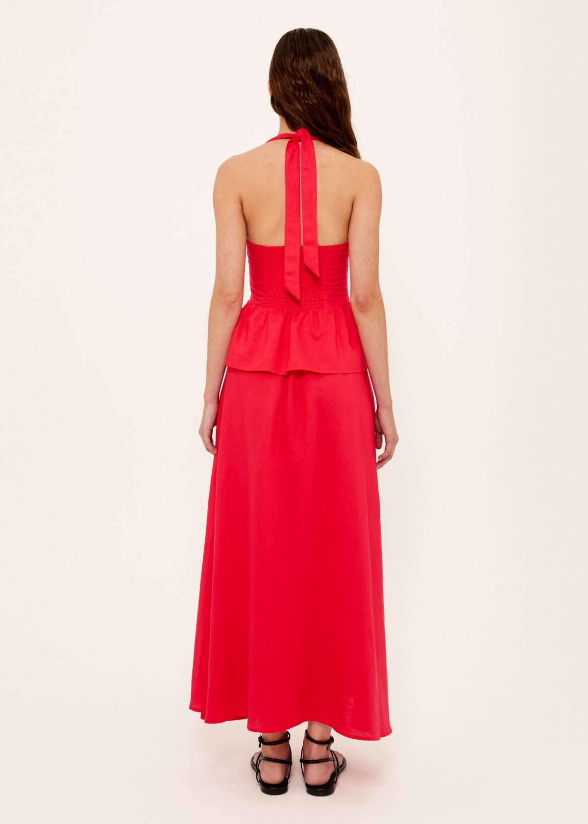 Back view of the Red Linen Blend Halter Peplum Top with a halter neckline with tie back and a shirred back panel.