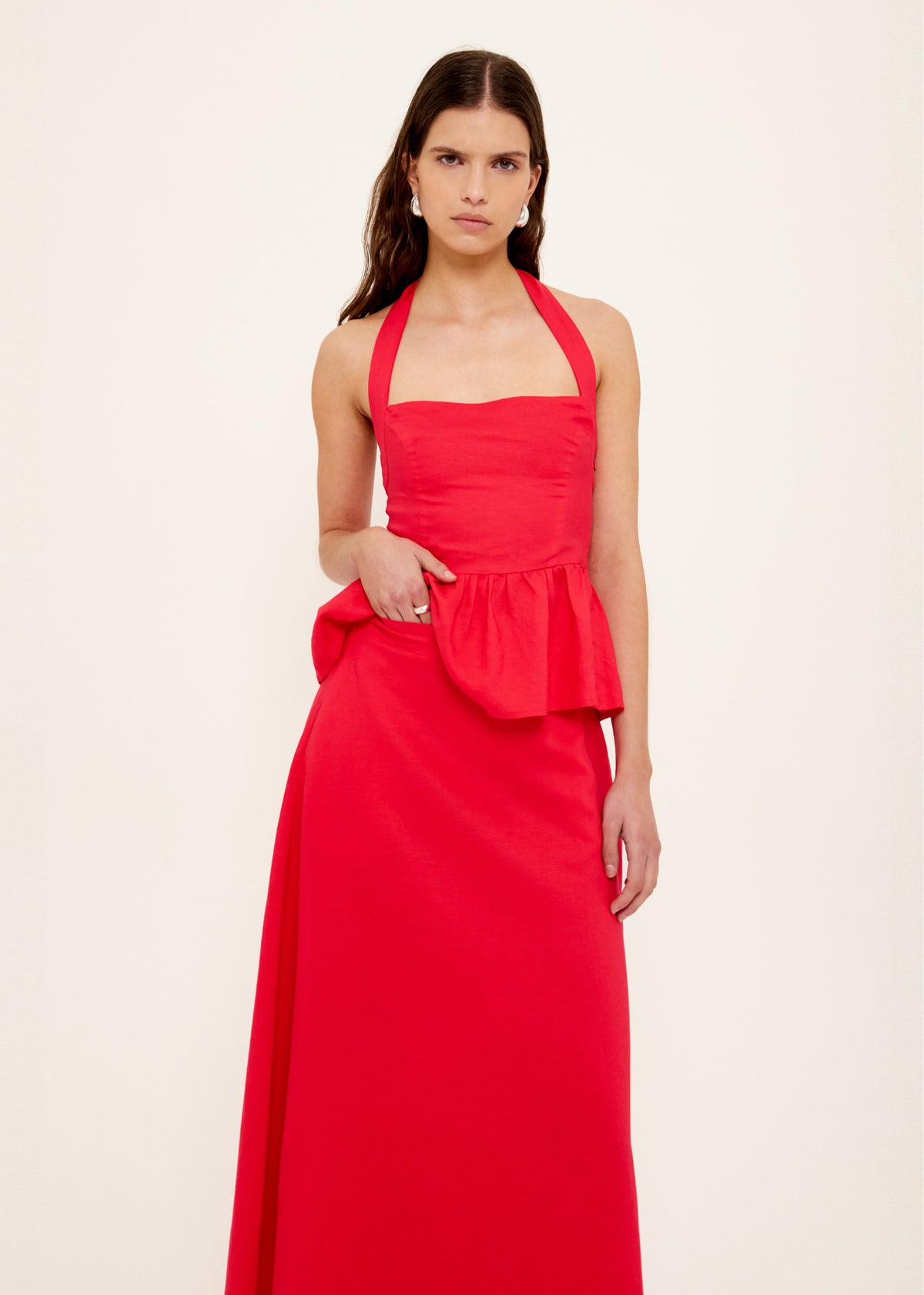 Model wearing Red Linen Blend Maxi Skirt with a full-length hemline and a high-waisted fit, turned to the side.