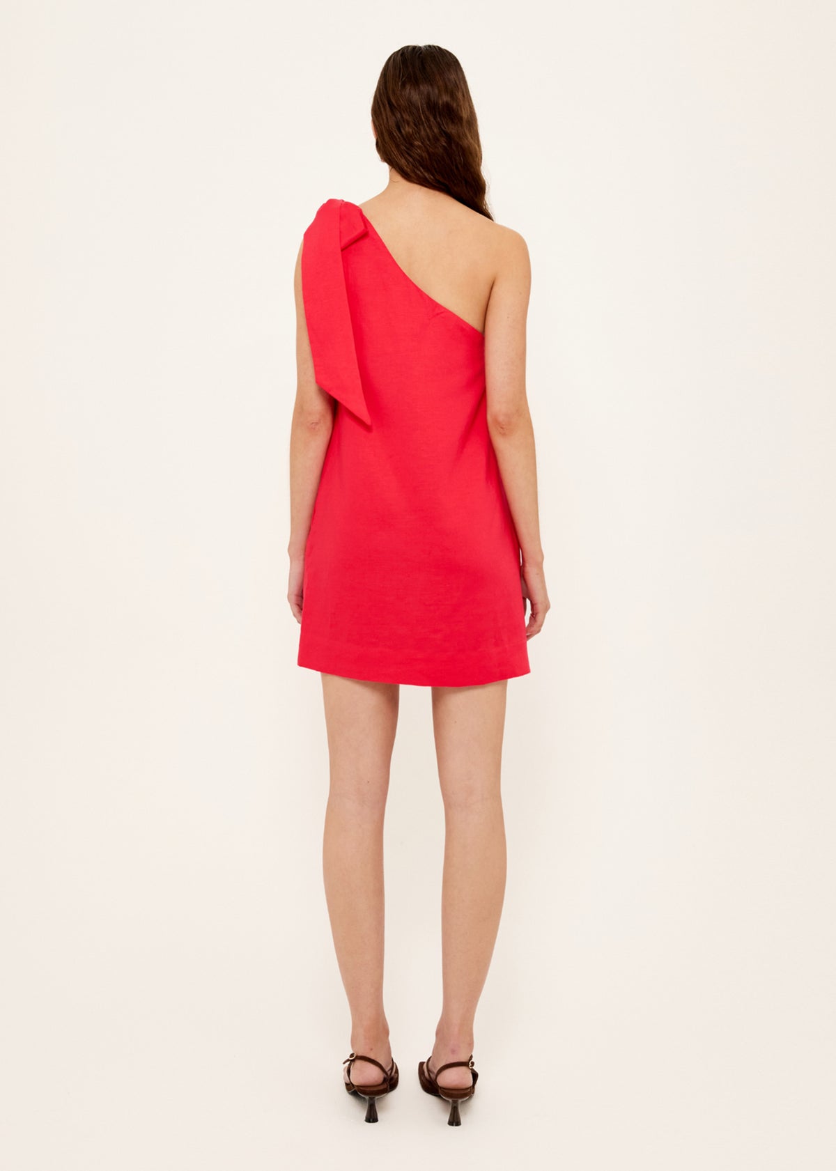 Back view of the Red Linen Blend One Shoulder Mini Dress with a statement self-tie bow detail and a one-shoulder neckline.