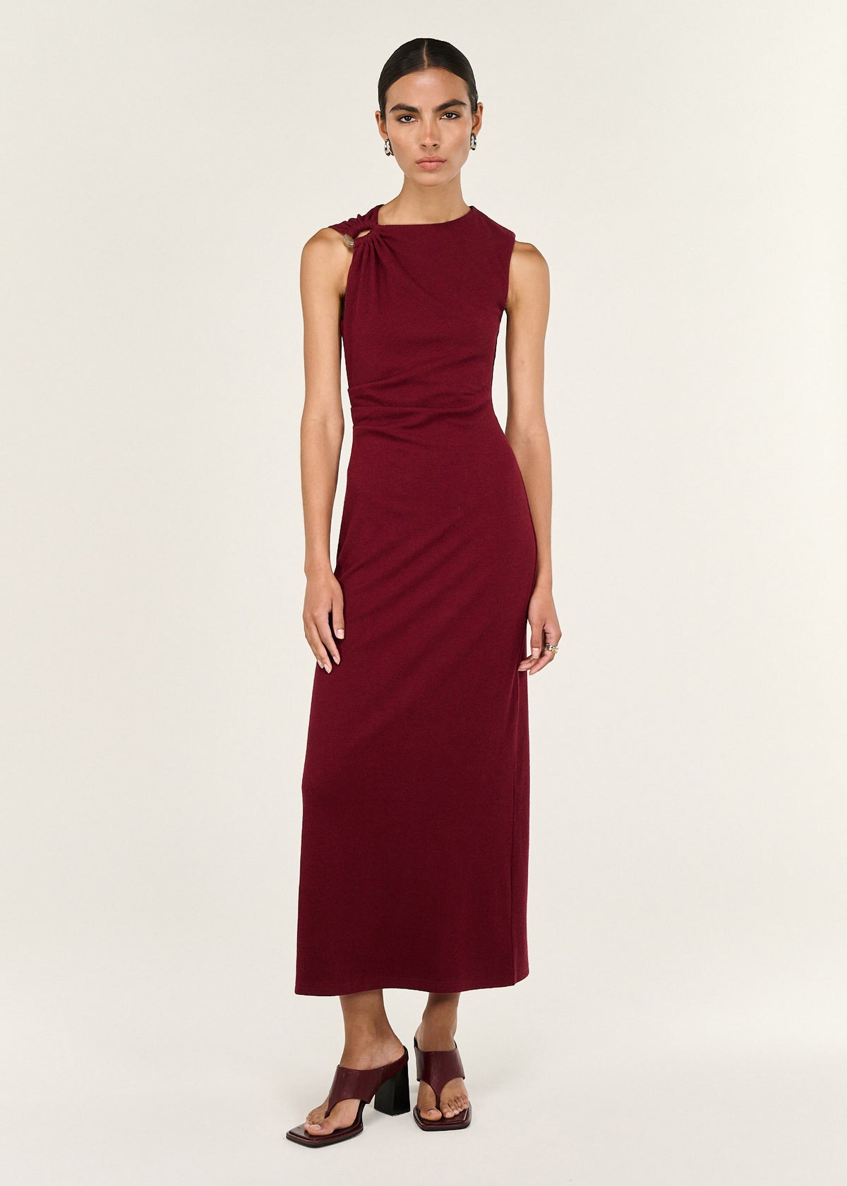 Model wearing Red Stretch Jersey Midi Dress with a crew neckline and an asymmetric gathered shoulder with ring detail.