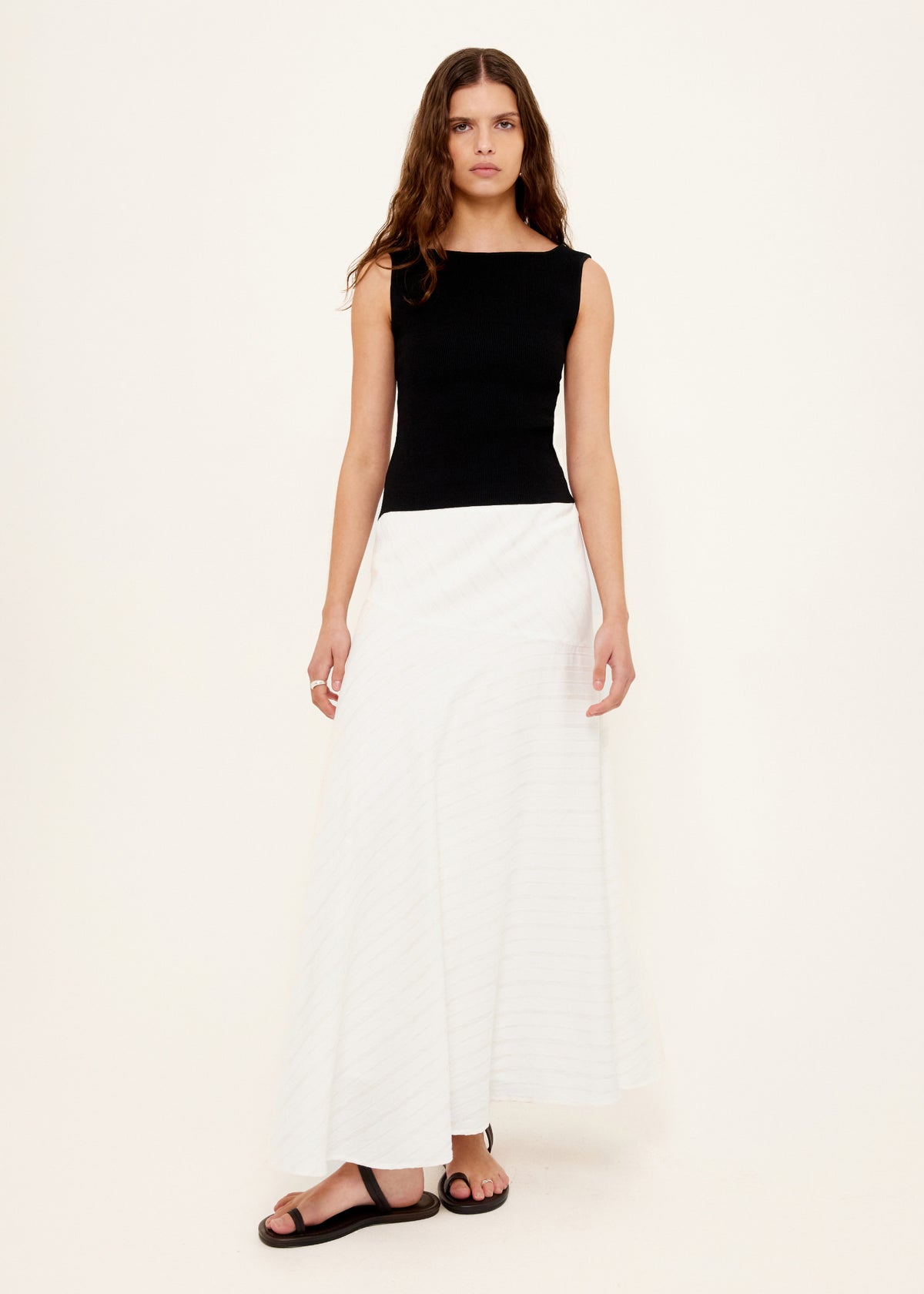 Model wearing Reversible Black Knit Tank Top with a reversible neckline - scoop or boat neck and a fitted silhouette.