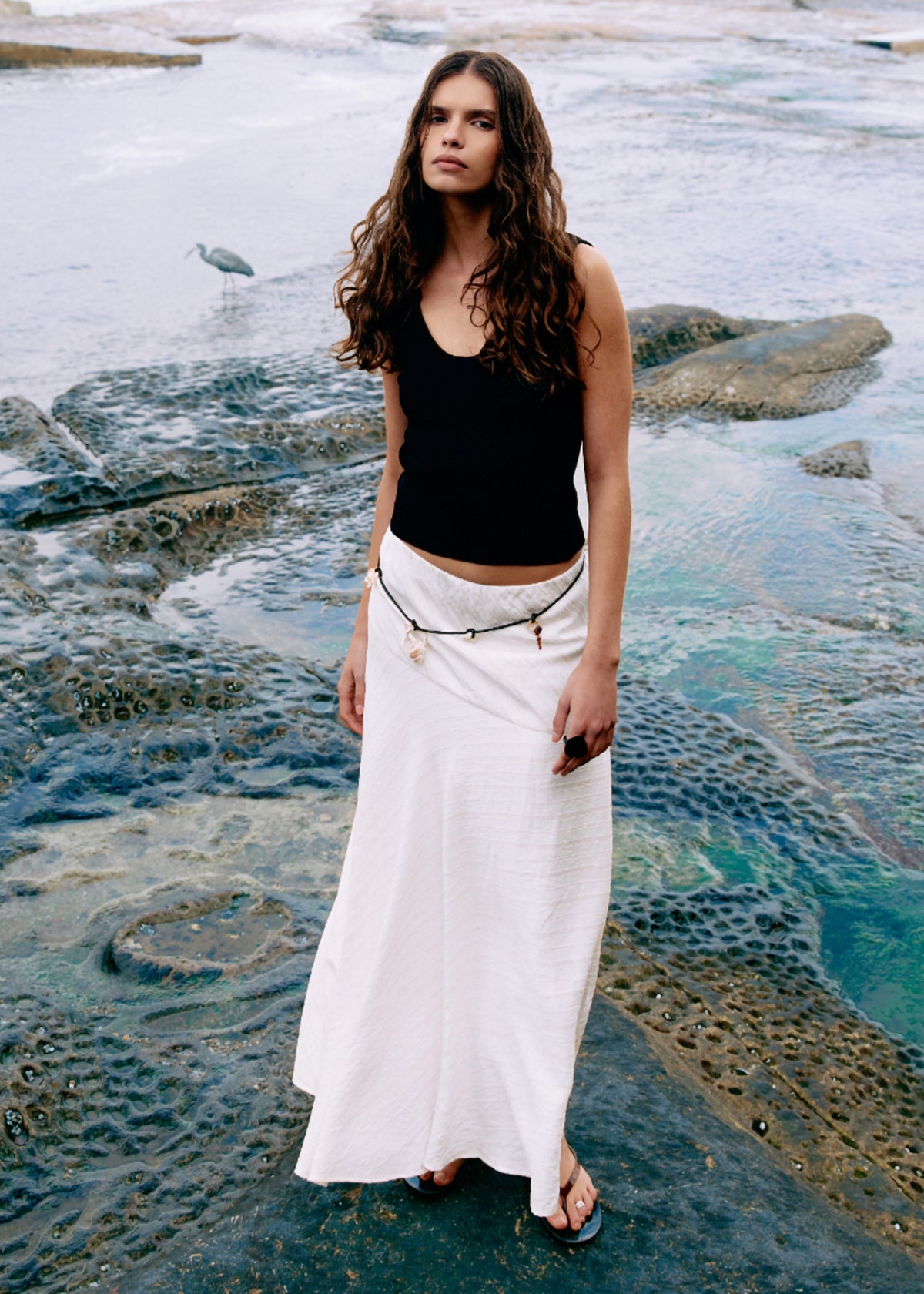 Model wearing Reversible Black Knit Tank Top, showing a reversible neckline - scoop or boat neck and a fitted silhouette.