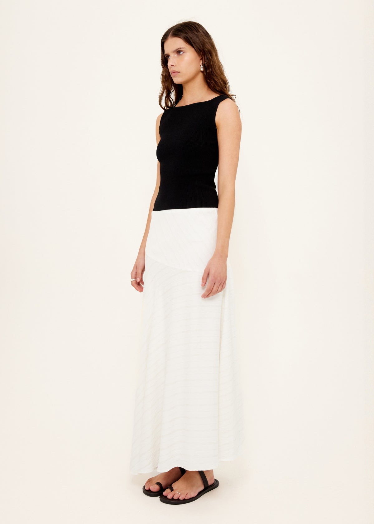Model wearing Reversible Black Knit Tank Top with a ribbed stretch knit and a mid-weight feel.