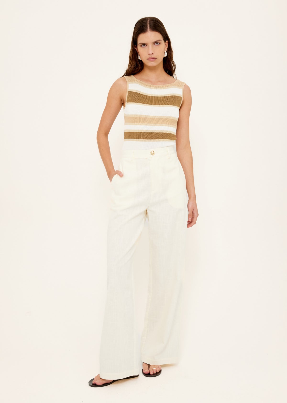 Model wearing Reversible Stripe Knit Tank, showing a ribbed knit texture and a wide neutral stripe design.