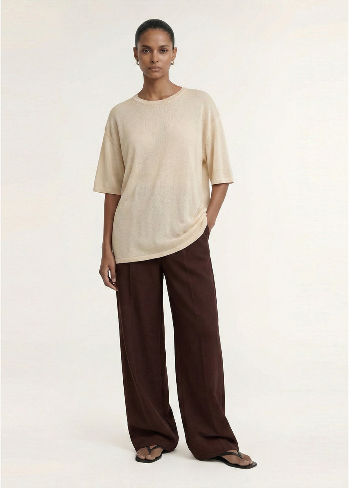 Model wearing Round Neck Oversized Knit Tee in Ecru with a lightweight knit fabrication and a round neckline.