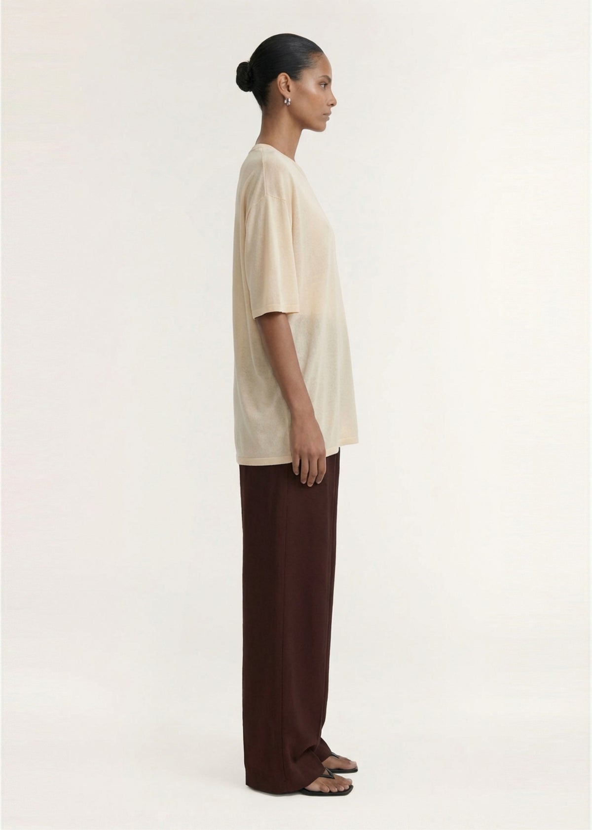 Side view of the Round Neck Oversized Knit Tee in Ecru, showing an oversized silhouette and a relaxed fit.