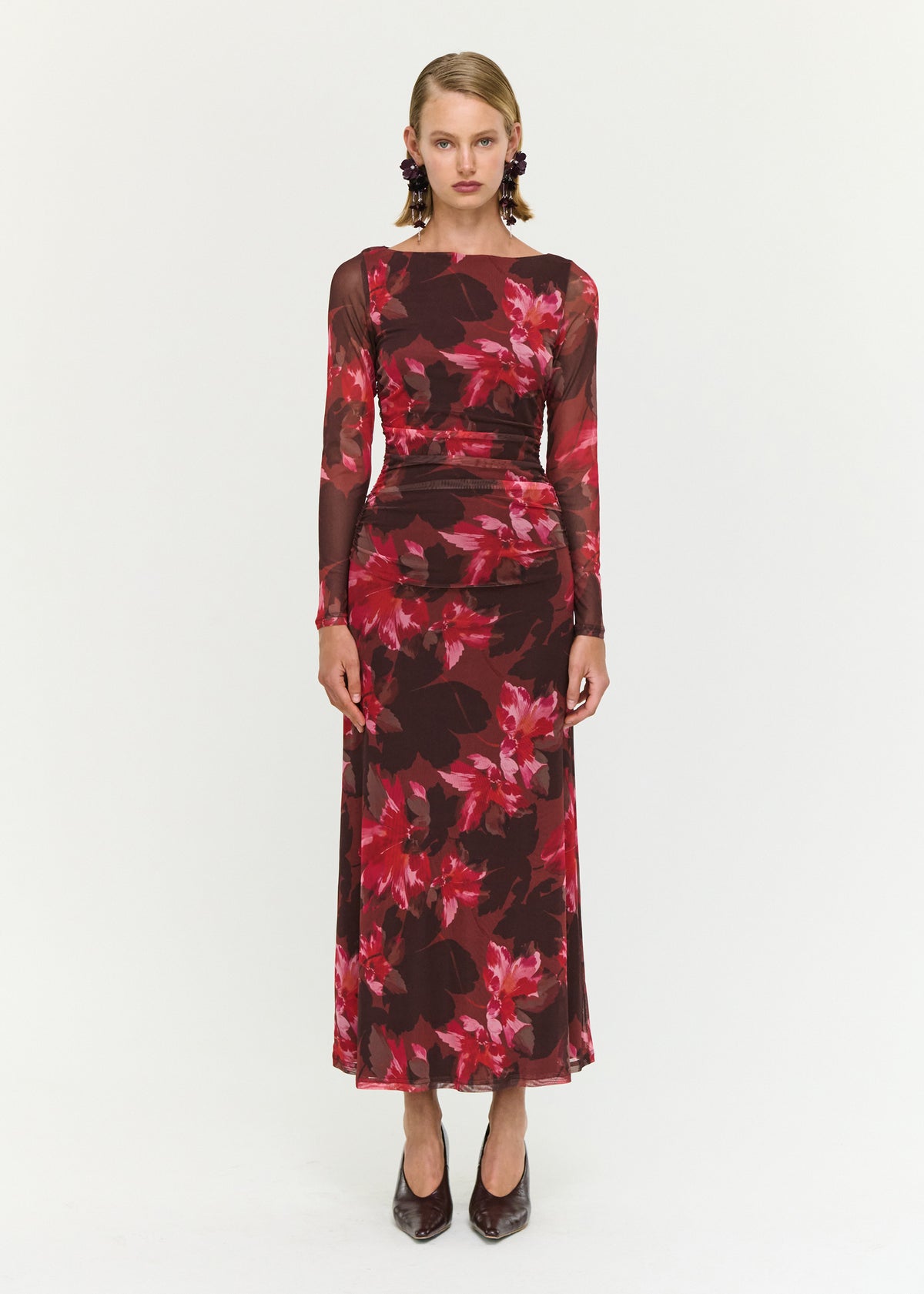 Model wearing Ruched Pink Floral Mesh Midi Dress with a sheer mesh fabrication and an oversized floral print.
