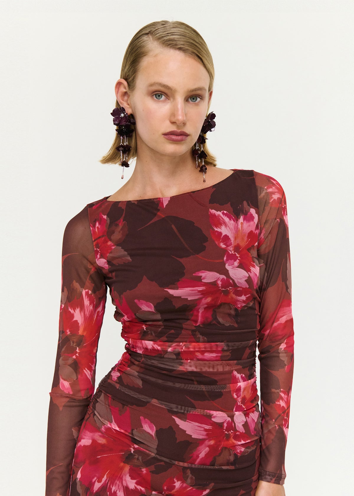 Close-up of the Ruched Pink Floral Mesh Midi Dress, showing a boat neckline and long sheer sleeves.