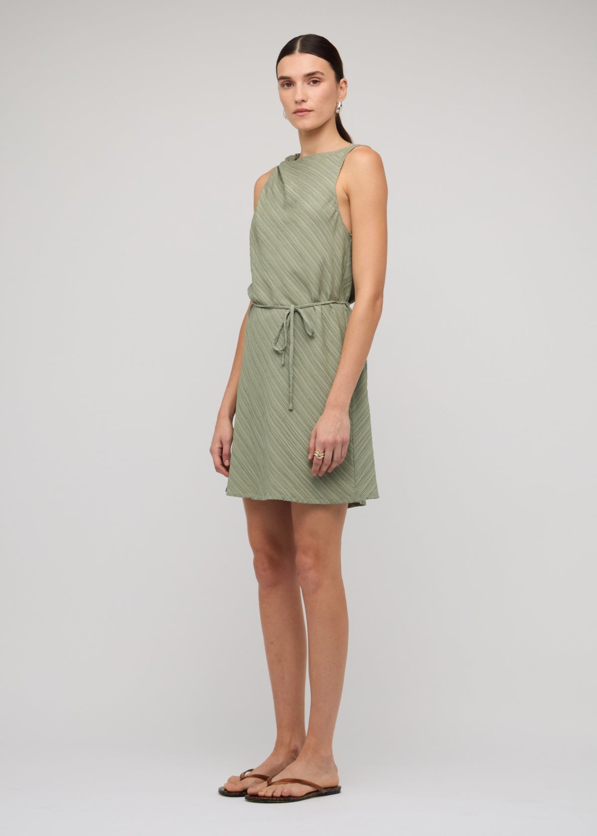 Side view of the Sage Green Mini Dress With Tie Waist, showing a mini length and a sage green colour-way.