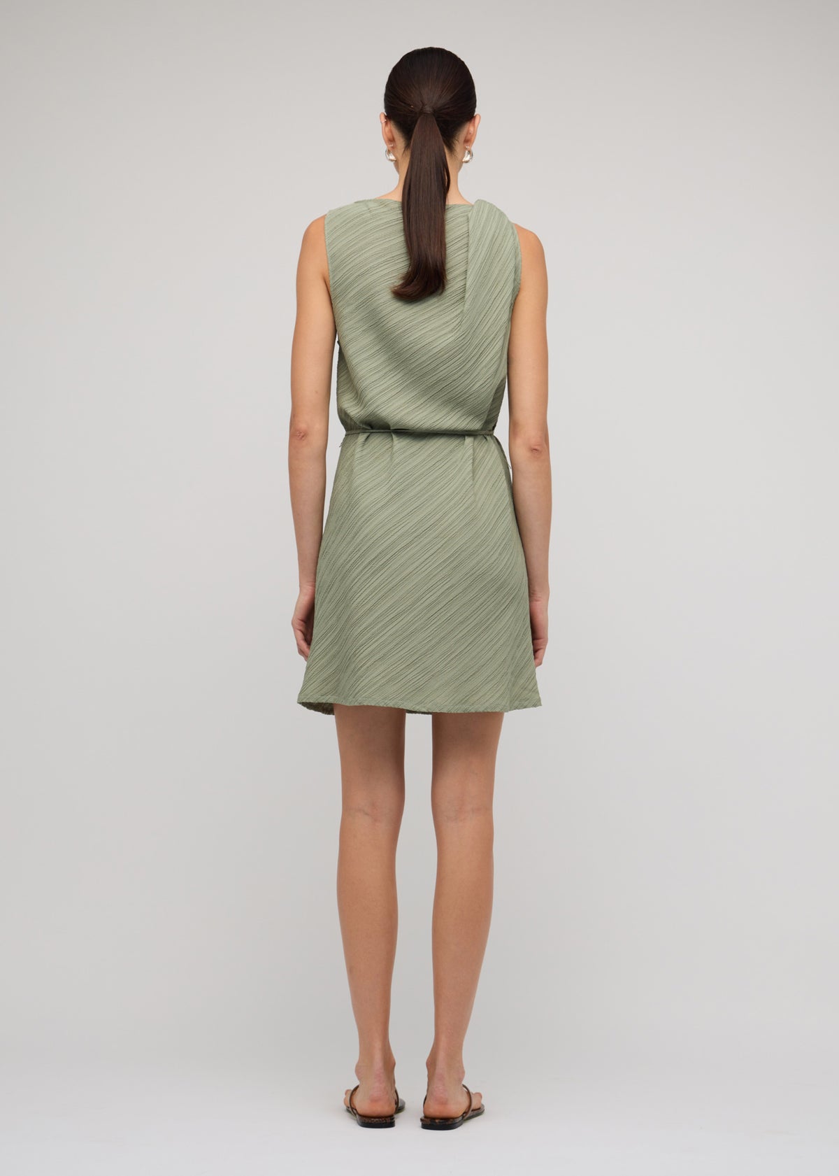 Back view of the Sage Green Mini Dress With Tie Waist with a removable waist tie and a textured fabrication.