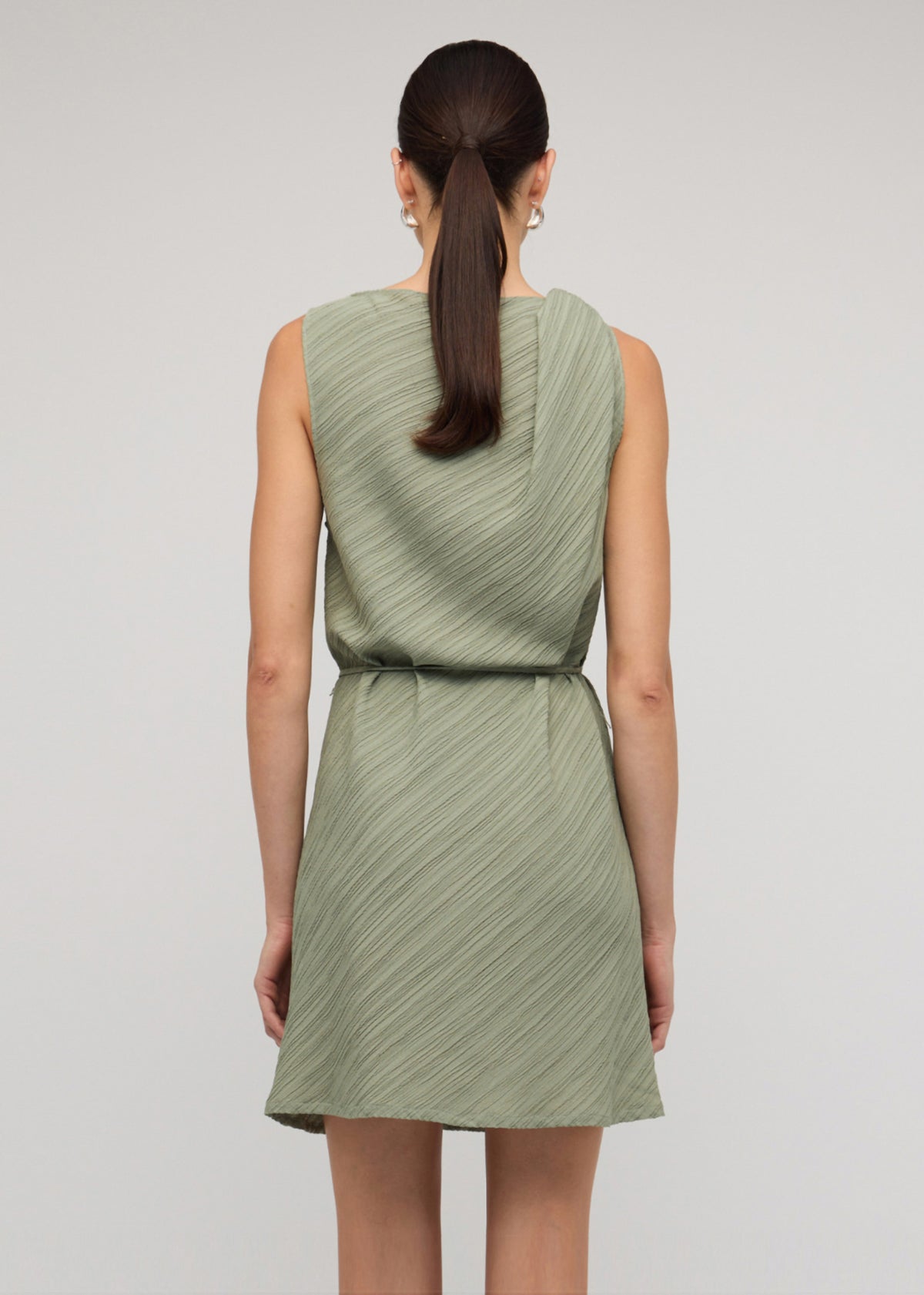 Back view of the Sage Green Mini Dress With Tie Waist, showing a removable waist tie and a textured fabrication.