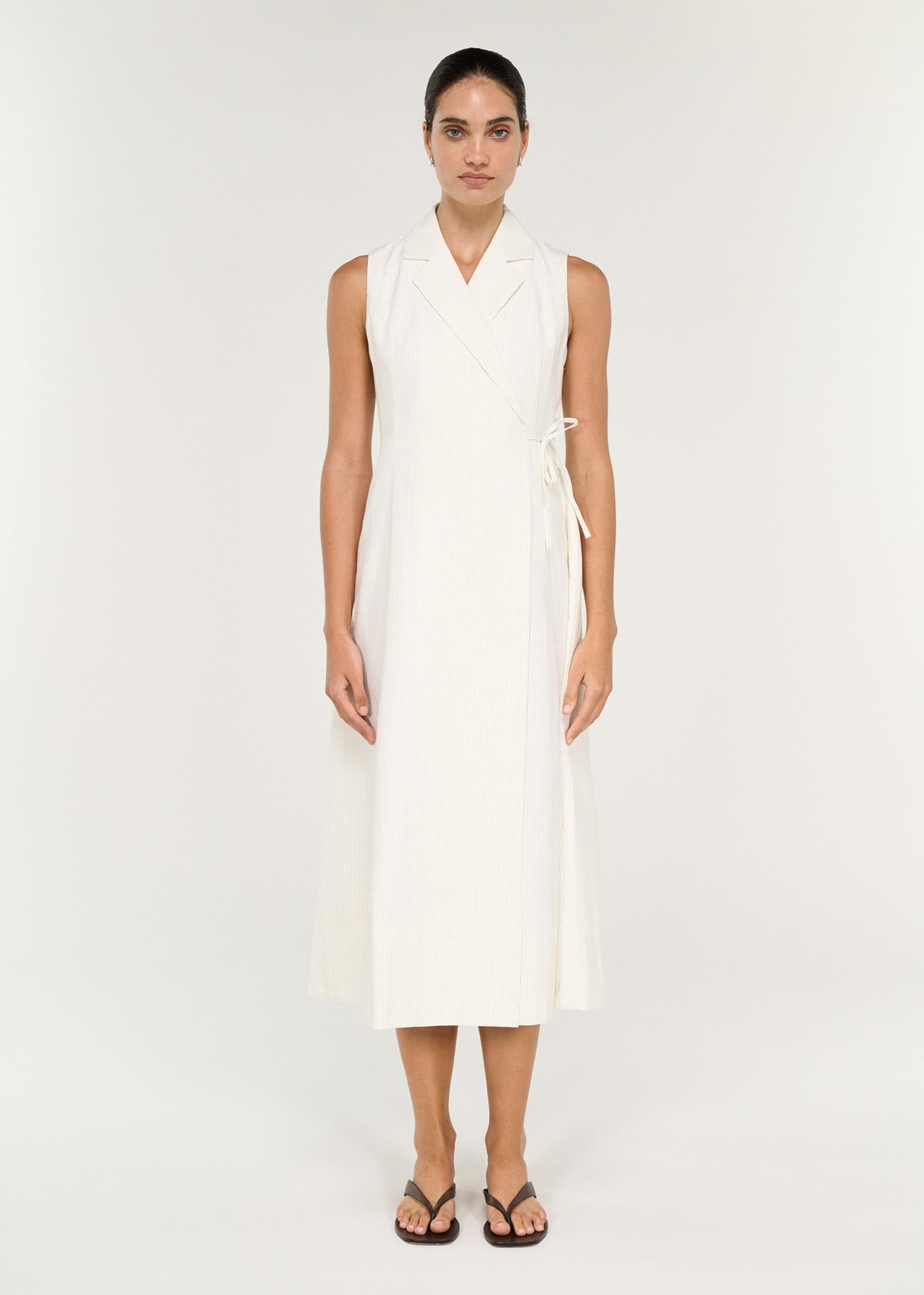 Model in a sleeveless Cotton Blend Wrap Detail Midi Dress featuring a collared front and tie waist.