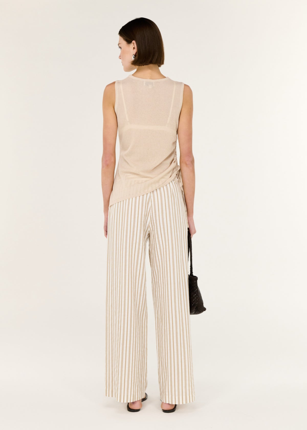 Back view of the Sheer Drawstring Knit Tank Top with a sleeveless cut and an adjustable side drawstring detail.
