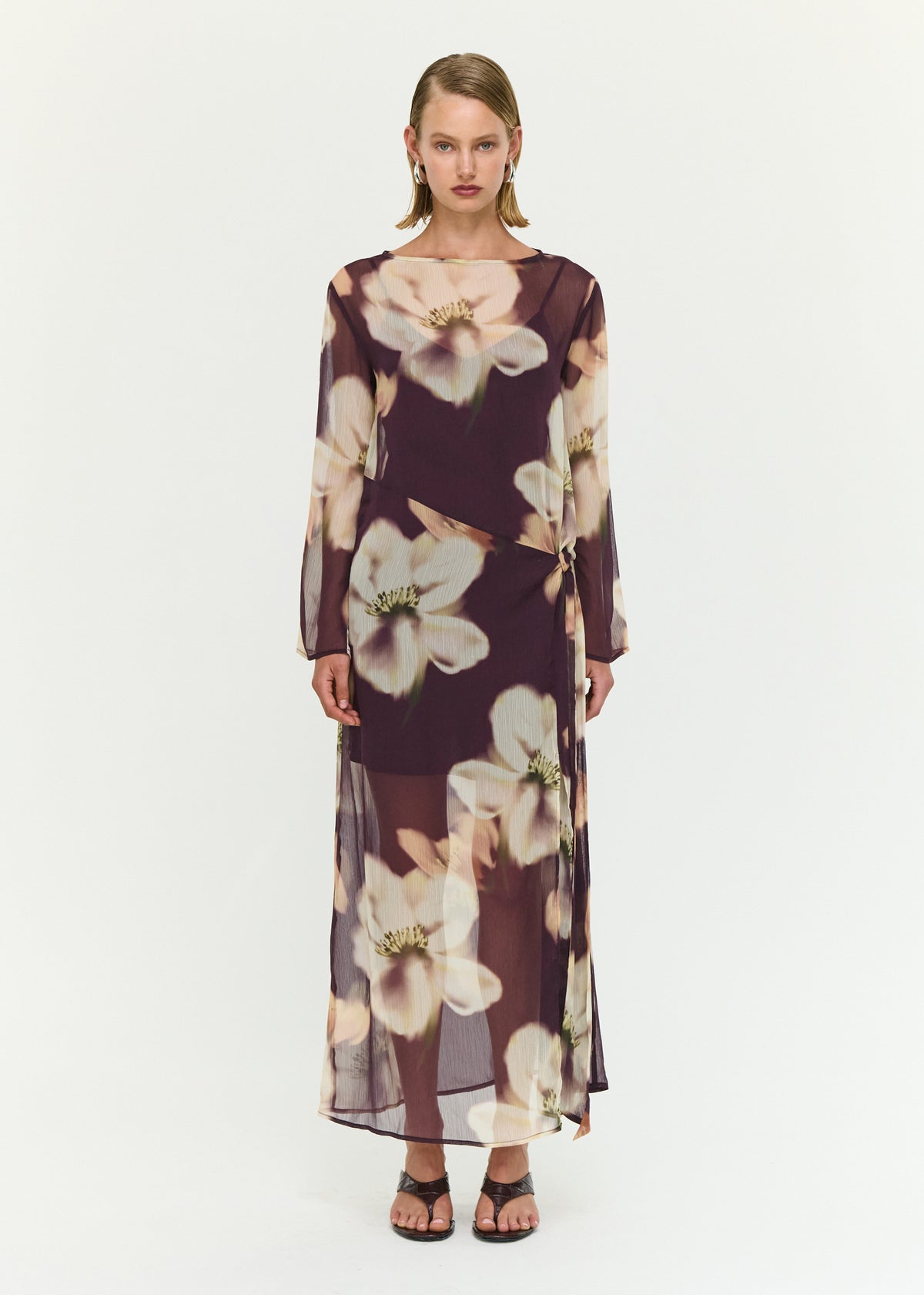 Model wearing Sheer Floral Maxi Dress with Tie Detail with a sheer mesh fabrication and an oversized floral print.
