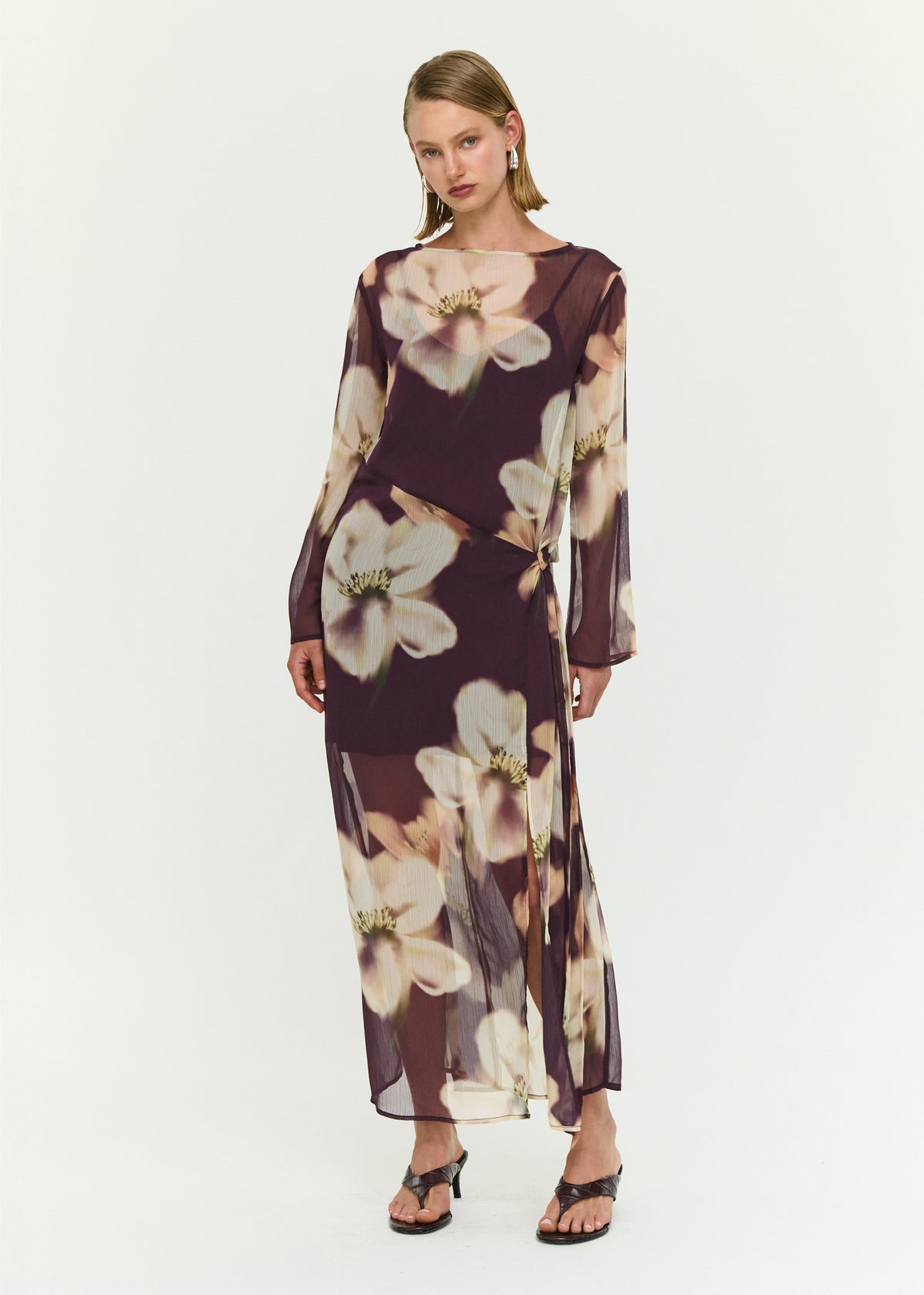 Model wearing Sheer Floral Maxi Dress with Tie Detail, showing a wrap-style waist with adjustable tie detail and a fitted silhouette.