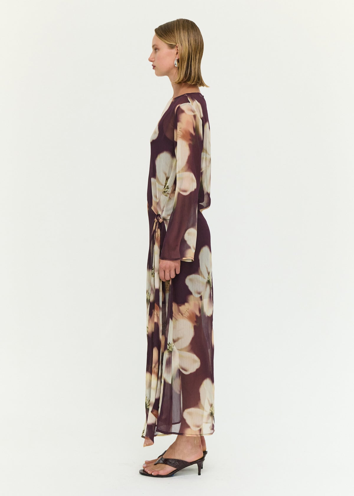 Side view of the Sheer Floral Maxi Dress with Tie Detail, showing a sheer mesh fabrication and an oversized floral print.