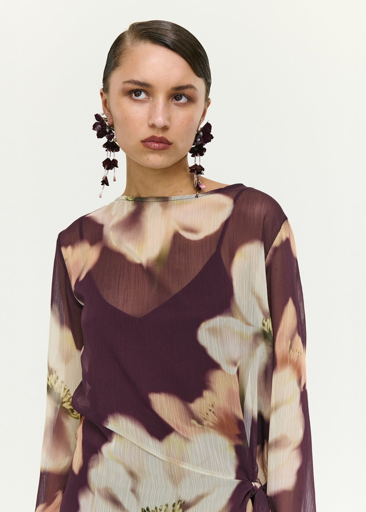Close-up of the Sheer Floral Mini Dress with Tie Detail, showing a polyester fabrication.