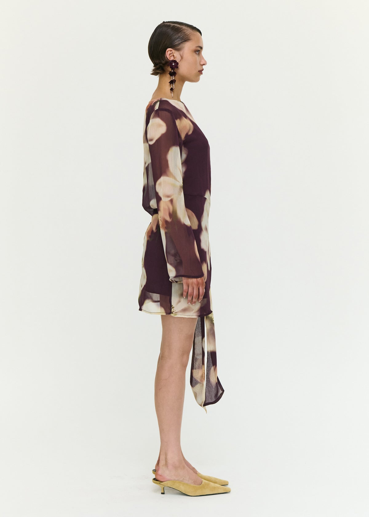 Side view of the Sheer Floral Mini Dress with Tie Detail, showing a polyester fabrication.