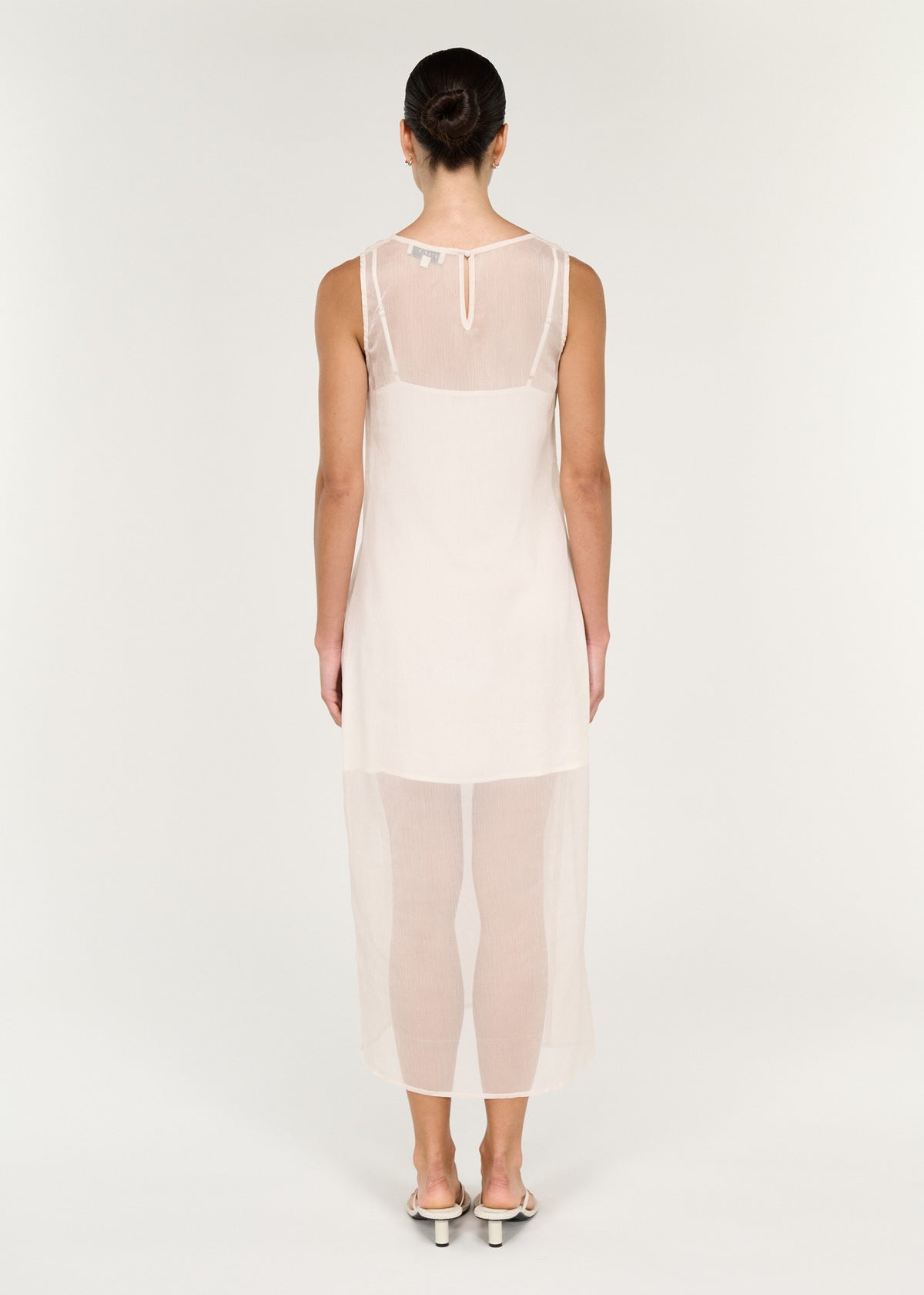 Back view of the Sheer Layered Slip Midi Dress in Cream with a keyhole button closure at back neck and a sheer lightweight fabrication.