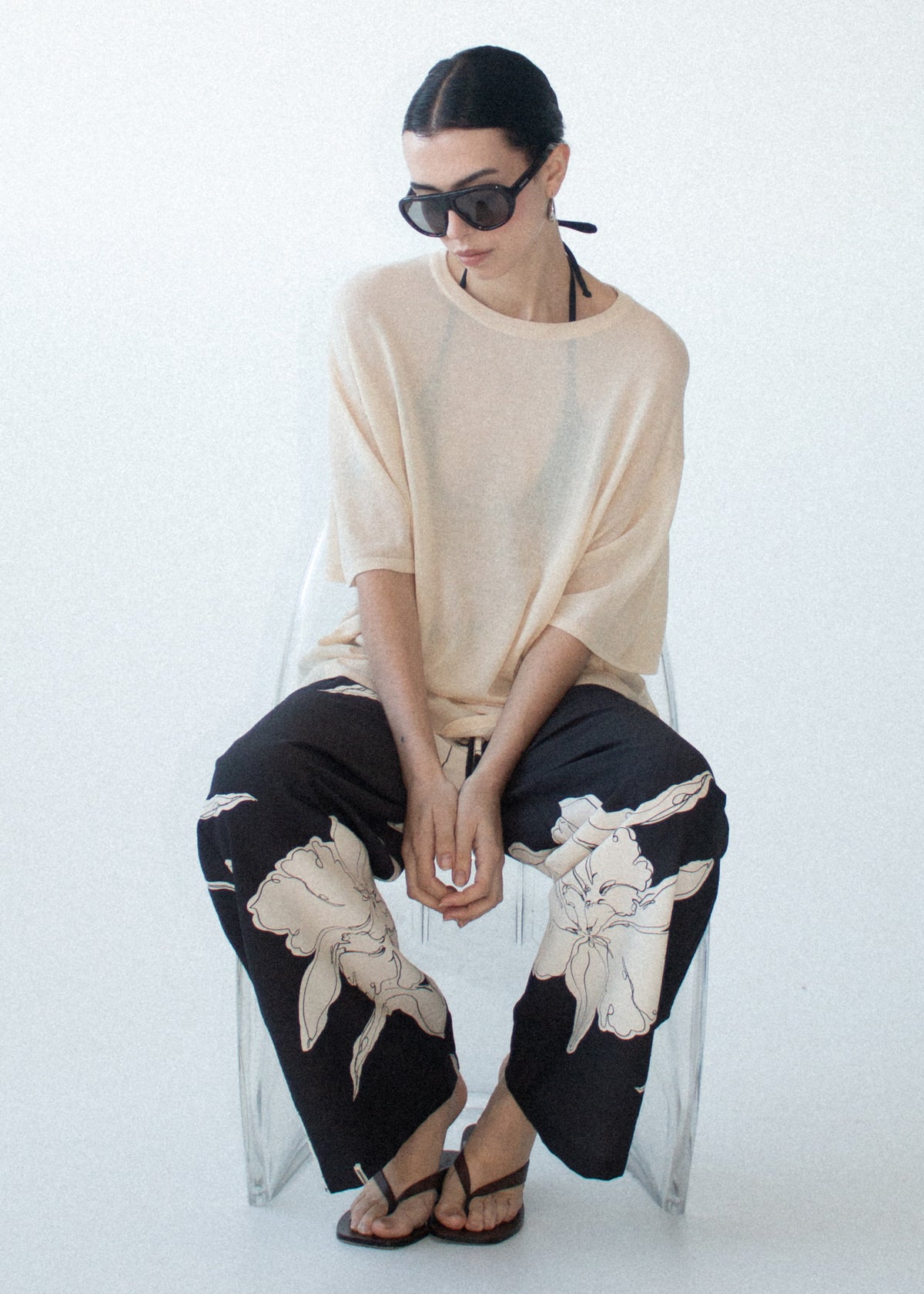Model seated wearing Sketched Floral Drawstring Pant with an adjustable drawcord tie and side seam pockets.