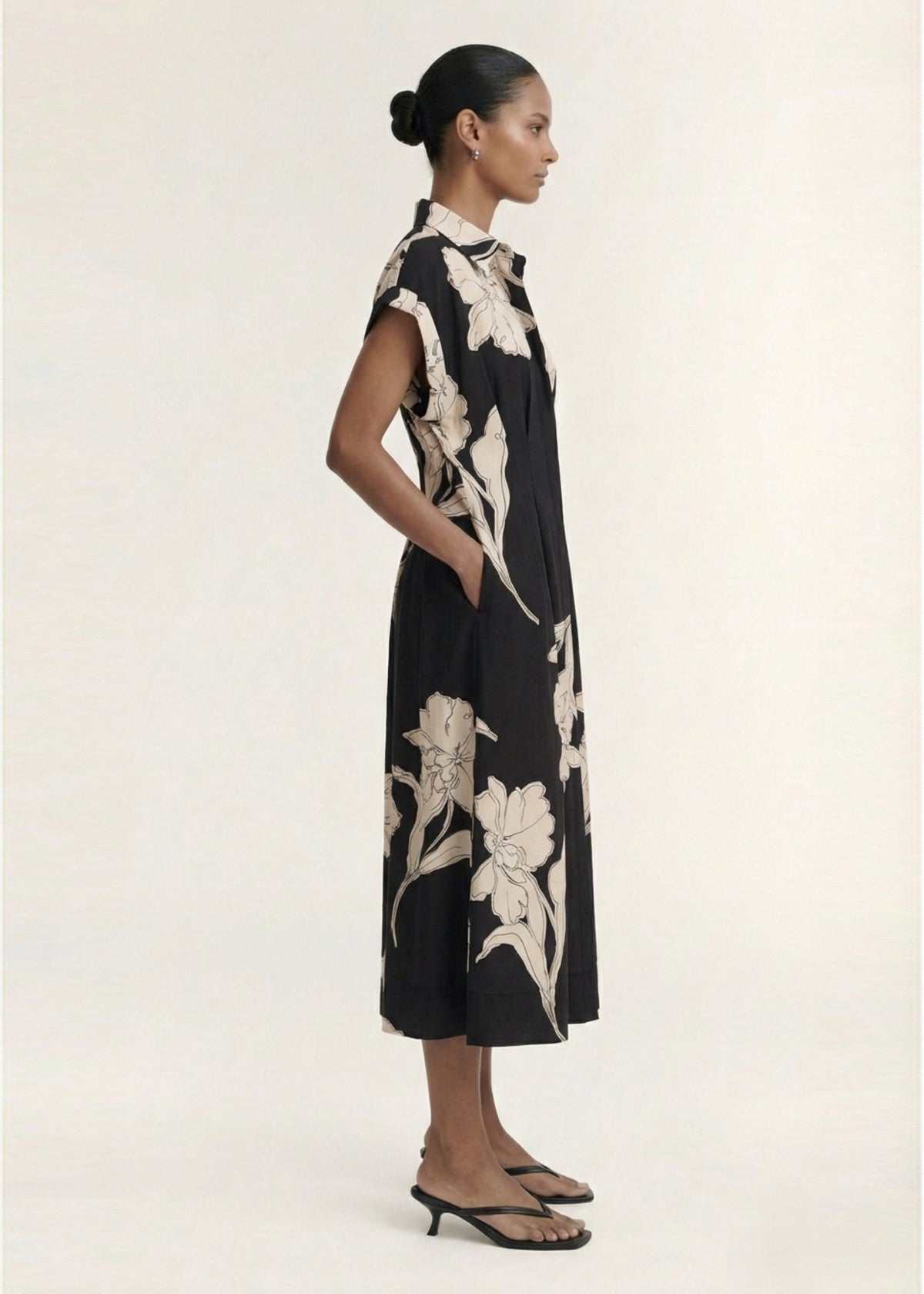 Model wearing Sketched Floral Midi Shirt Dress with a midi length silhouette and a lightweight woven fabrication, turned to the side.