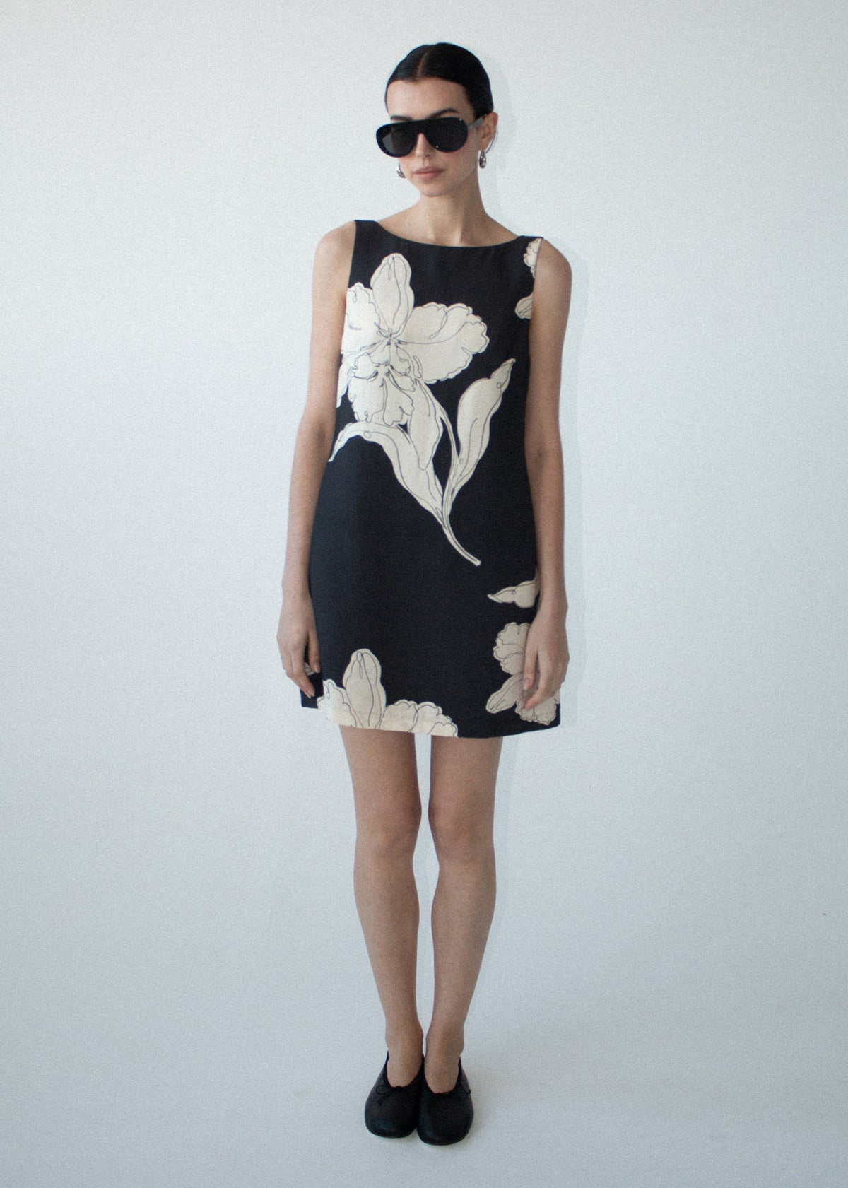 Model wearing Sketched Floral Sleeveless Mini Dress with a relaxed shift silhouette and a collared neckline.
