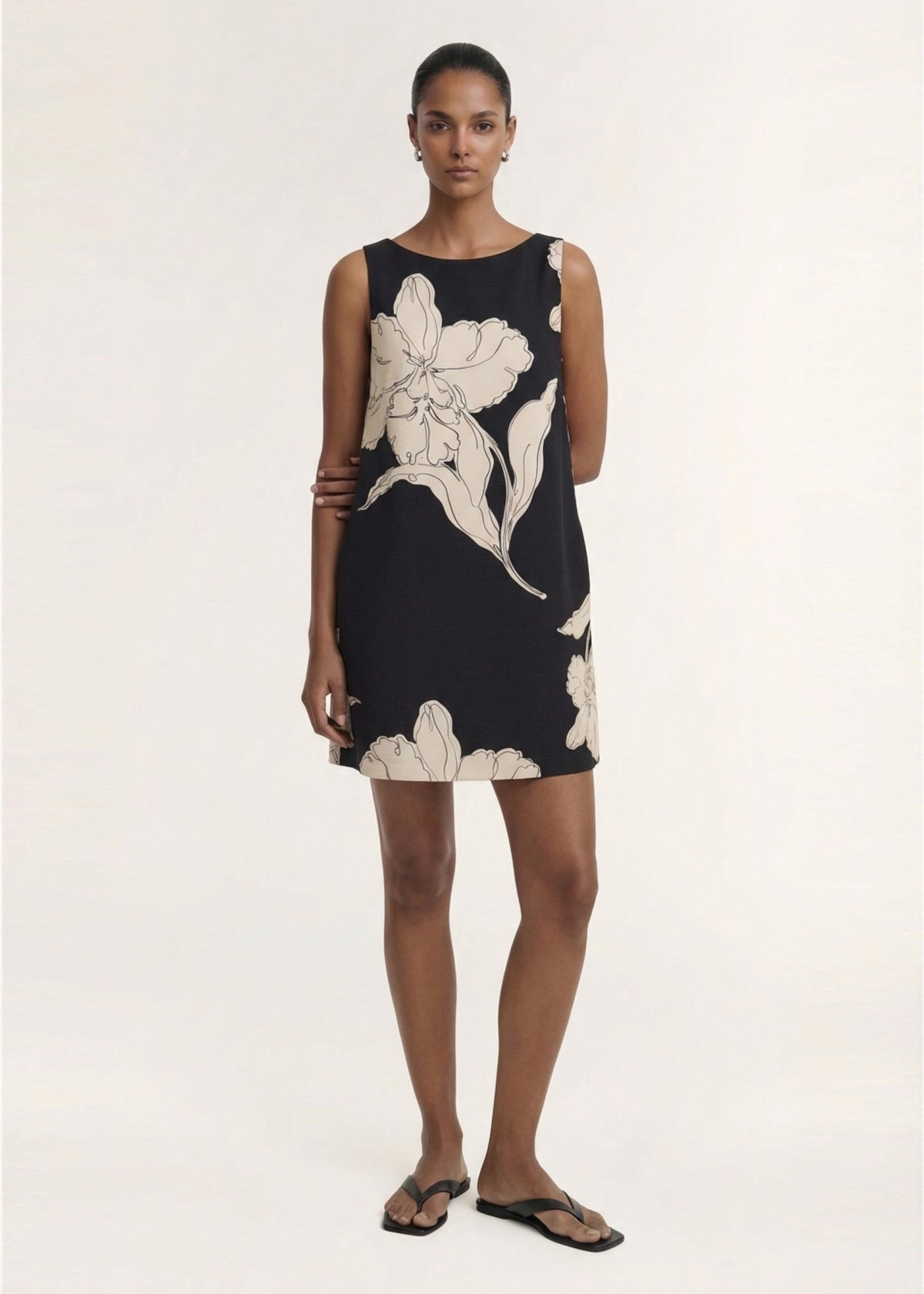Model wearing Sketched Floral Sleeveless Mini Dress, showing an easy slip-on styling and a lightweight woven fabrication.