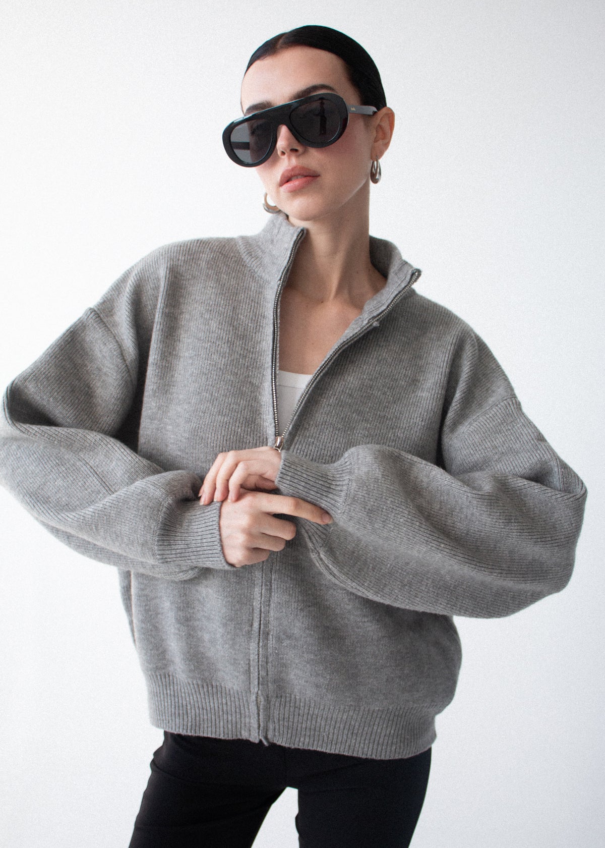 Model wearing Soft Grey Oversized Zip Cardigan, showing dropped shoulders and long voluminous sleeves.