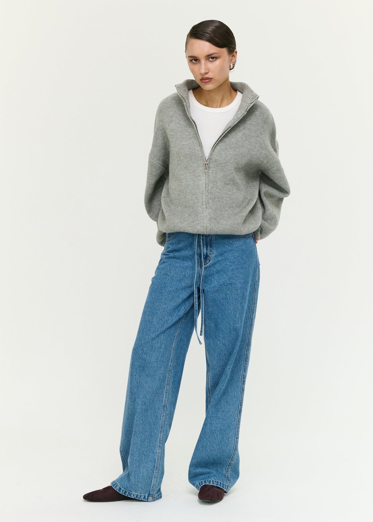 Angled view of the Soft Grey Oversized Zip Cardigan with dropped shoulders and long voluminous sleeves.