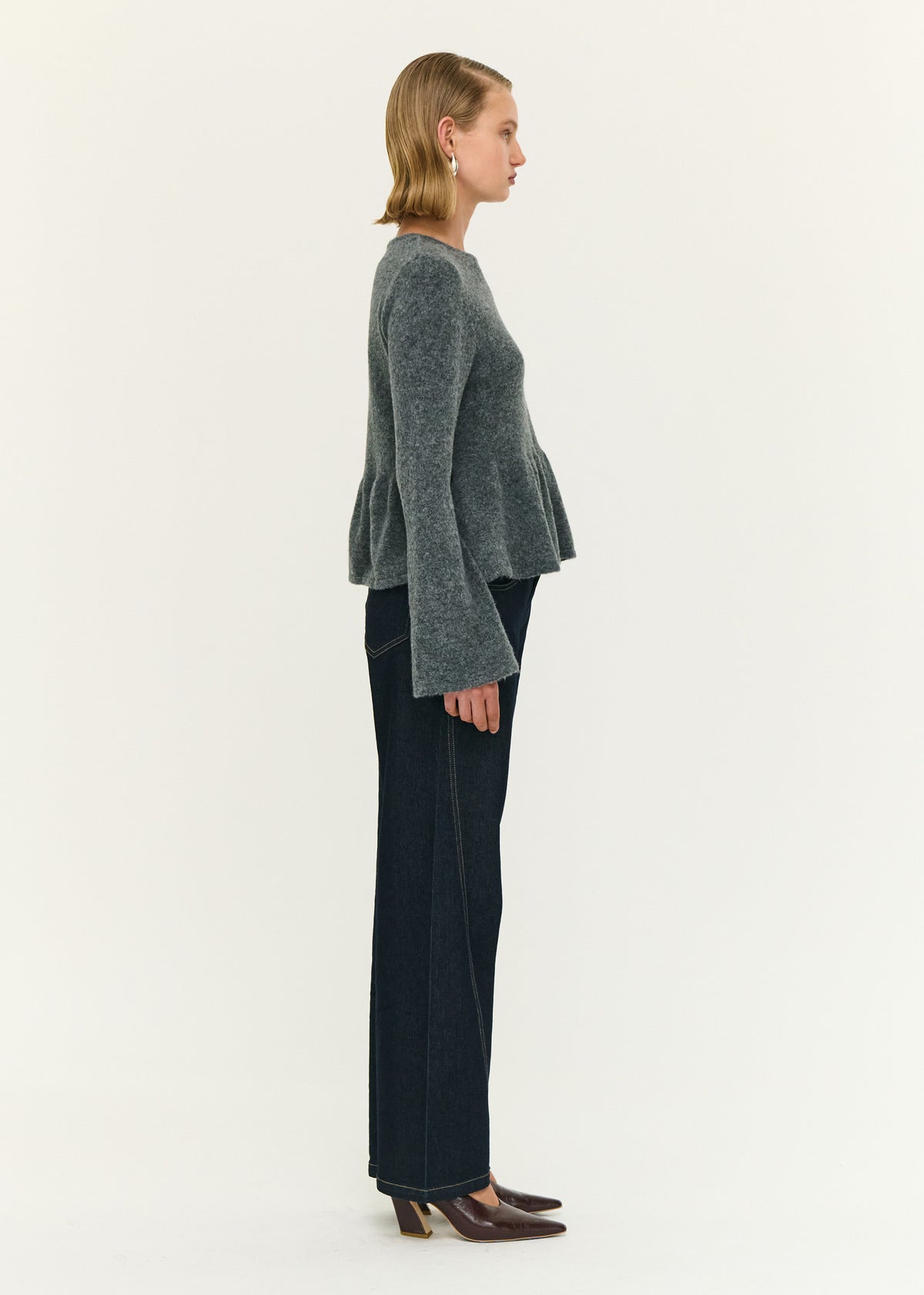 Side view of the Soft Knit Peplum Top with Flute Sleeve, showing a slip-on style and a soft brushed knit fabrication.