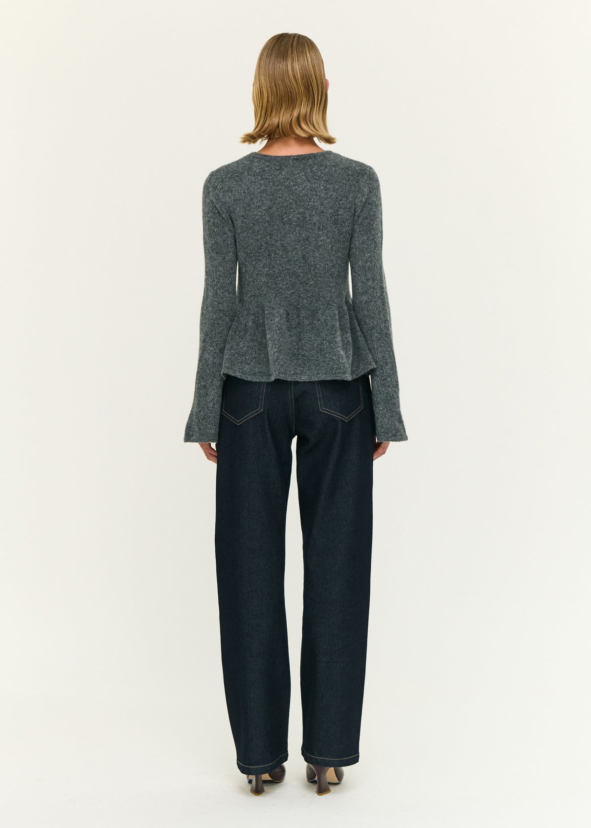 Back view of the Soft Knit Peplum Top with Flute Sleeve with a soft brushed knit fabrication and a fitted silhouette.