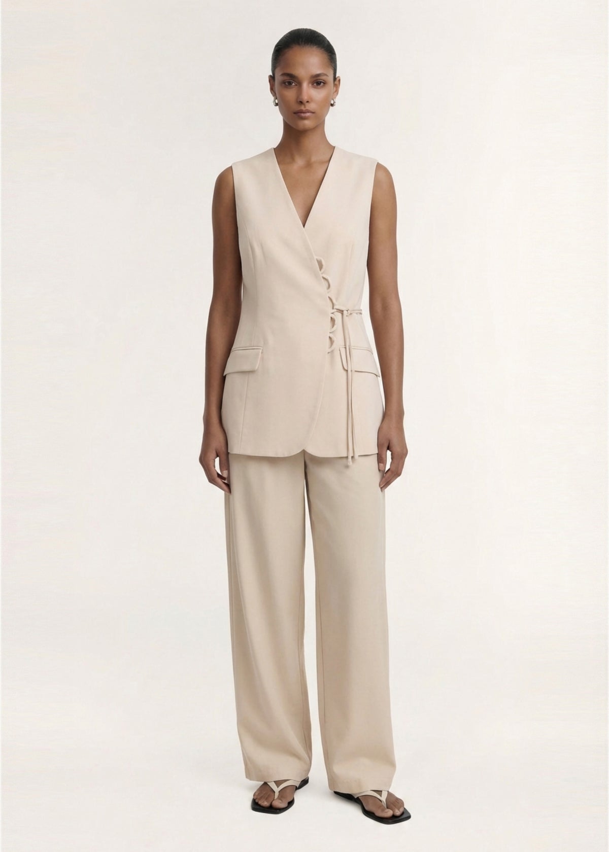Model wearing Stone Cotton Wrap Front Vest with a lightweight structured fabrication and a wrap-front V-neckline.