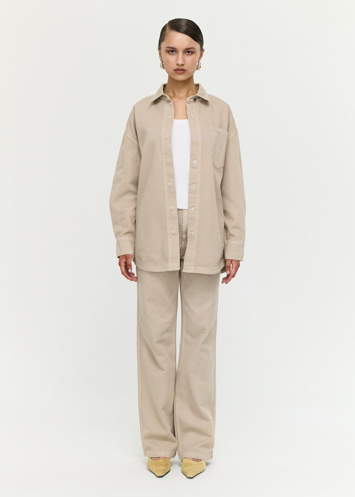 Model wearing Stone Wash Relaxed Denim Shacket with a structured cotton denim fabrication and a relaxed oversized fit.