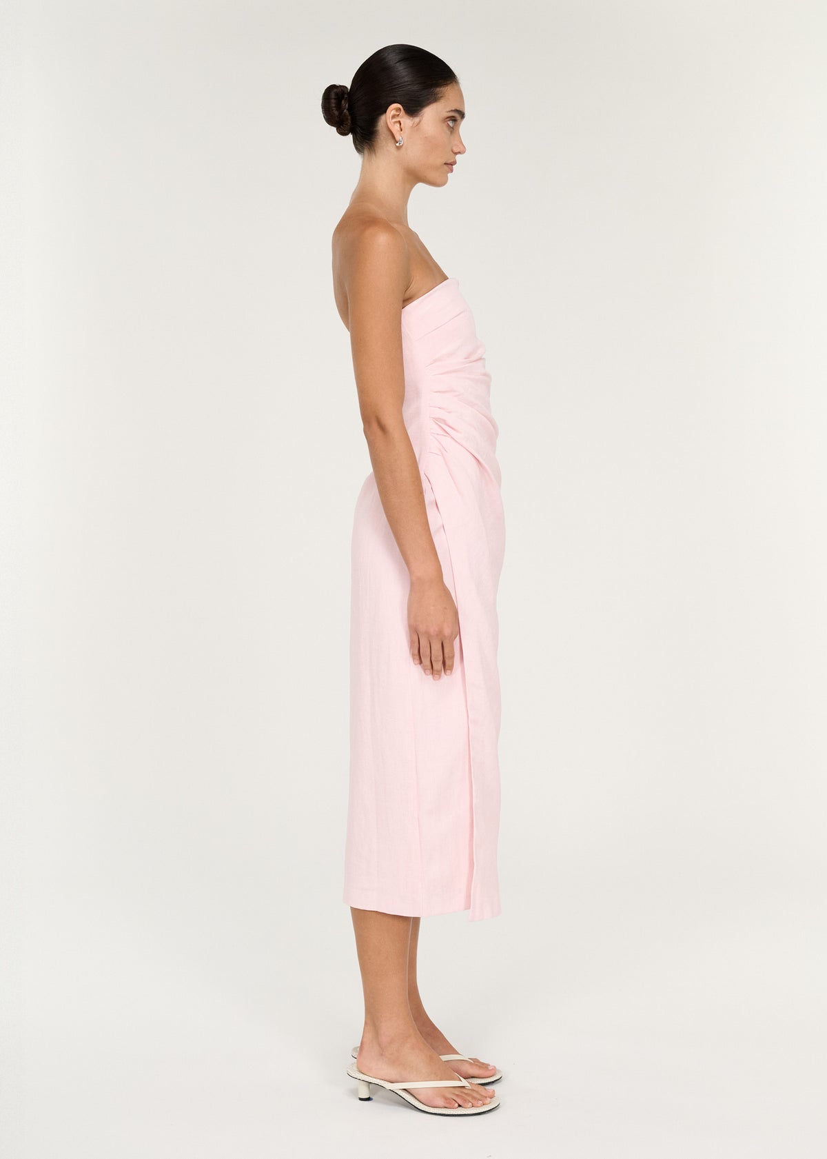 Side view of the Strapless Wrap Midi Dress in Soft Pink, showing a centre back zip closure and a clean, minimal finish.