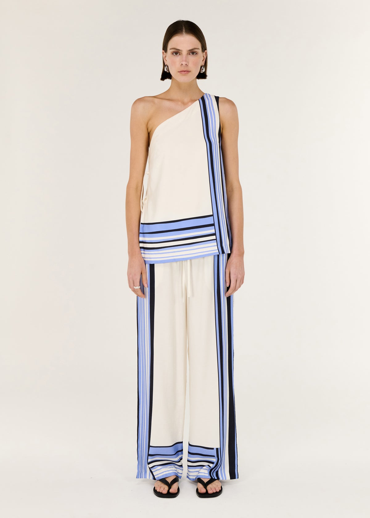 Model wearing Stripe One Shoulder Top with a one-shoulder neckline and an adjustable side tie detailing.