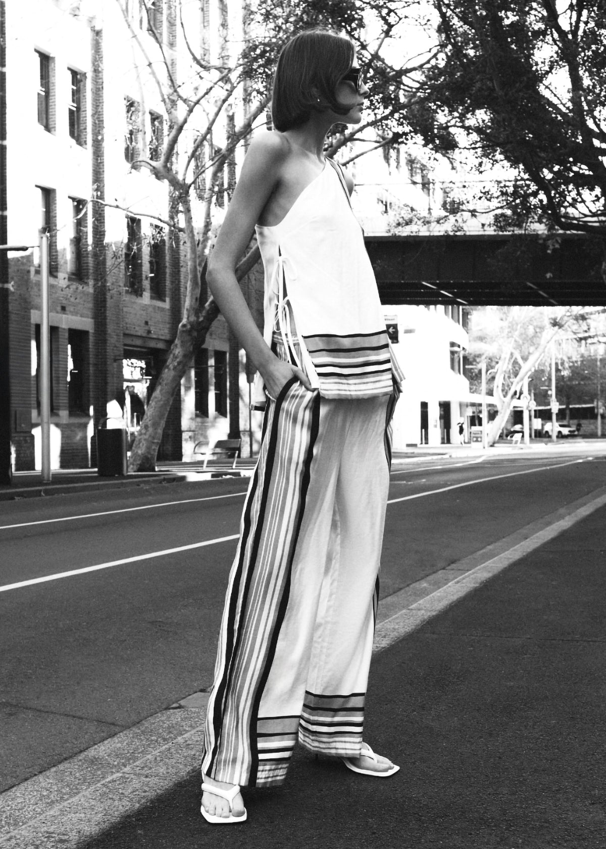 Model wearing Stripe One Shoulder Top with a fully lined and a one-shoulder neckline, turned to the side.