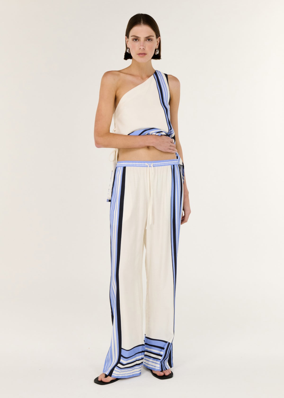 Model wearing Stripe Relaxed Wide-Leg Low Rise Pants, showing a fluid drape with soft structure and a spliced stripe detailing.