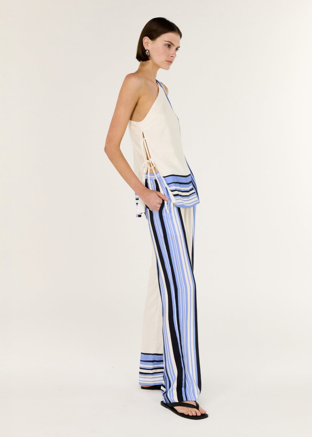 Model wearing Stripe Relaxed Wide-Leg Low Rise Pants with a spliced stripe detailing and a designed, turned to the side.