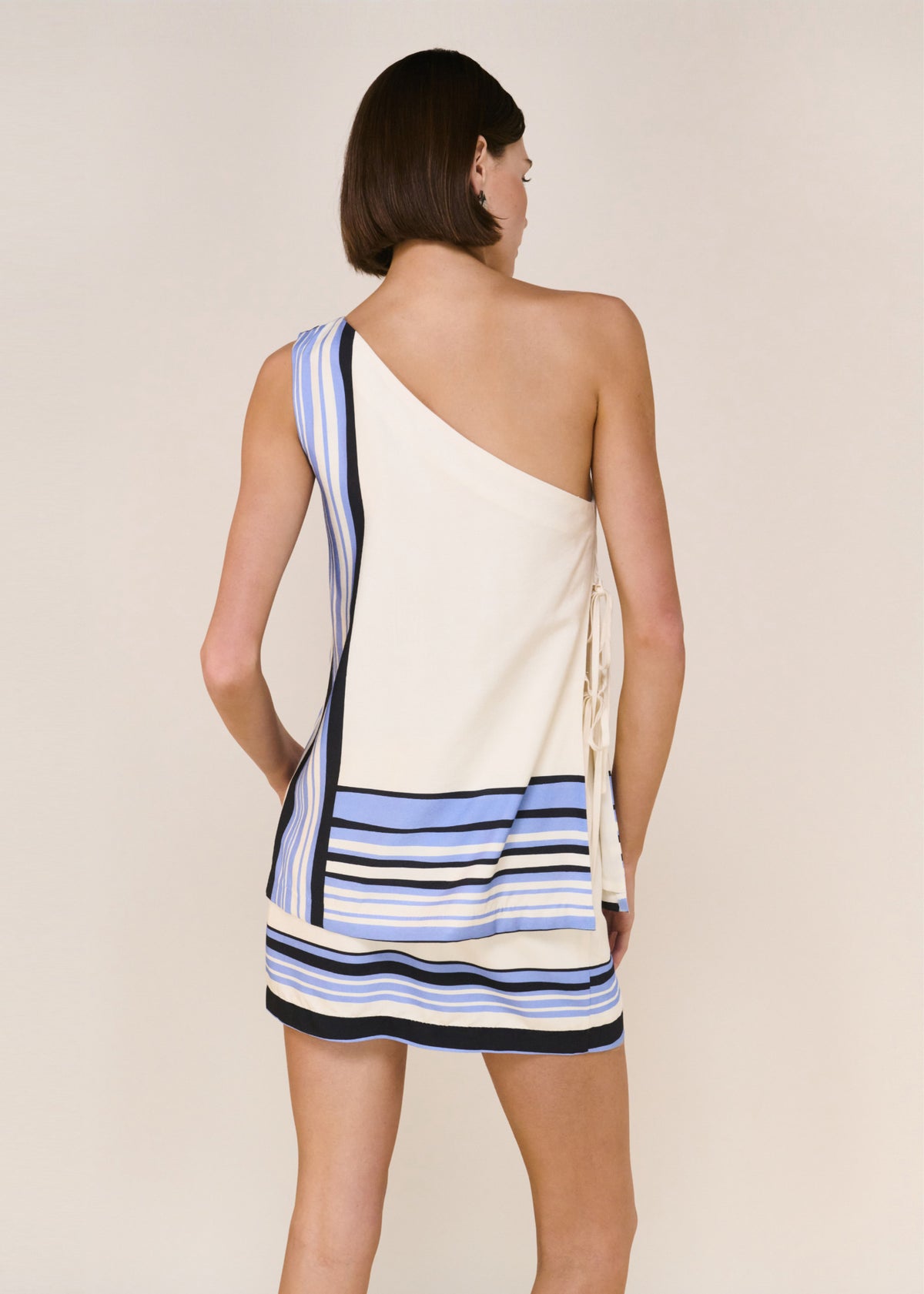 Close-up of the Stripe Wrap Mini Skirt, showing an adjustable wrap closure and a tailored yet fluid fit.